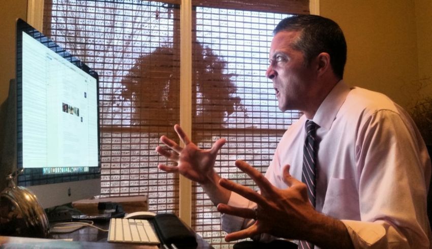 A man sitting in front of a computer screen.