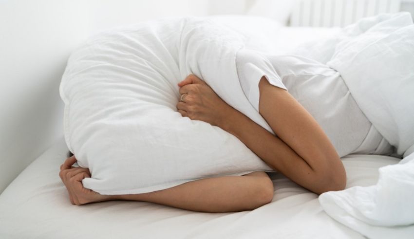 A woman laying on a bed with a pillow under her head.