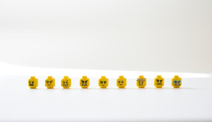 A group of yellow legos in a row on a white surface.