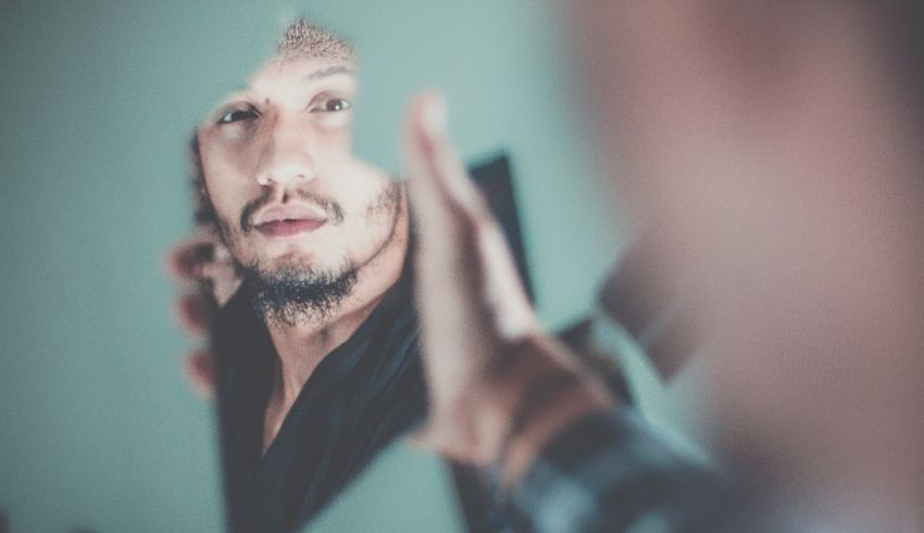 A man looking at his reflection in a mirror.