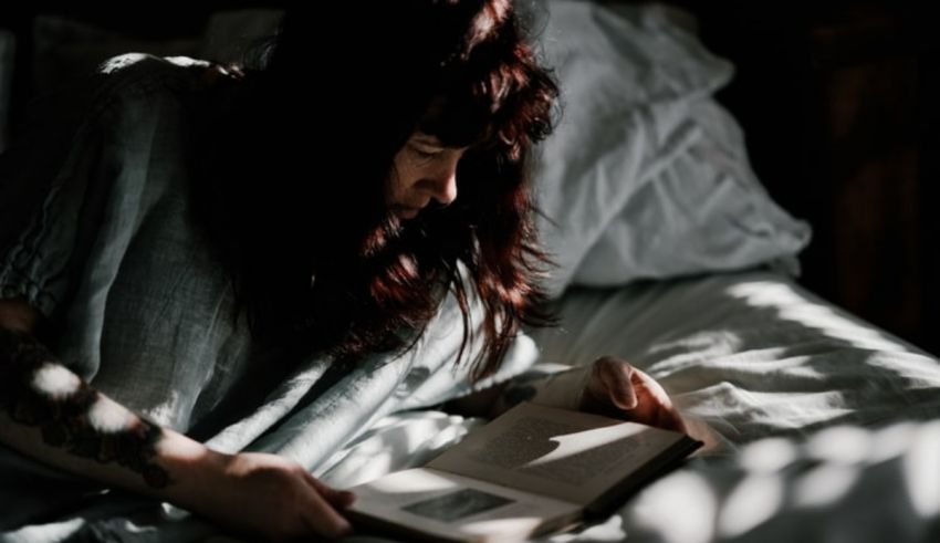 A woman reading a book in bed.
