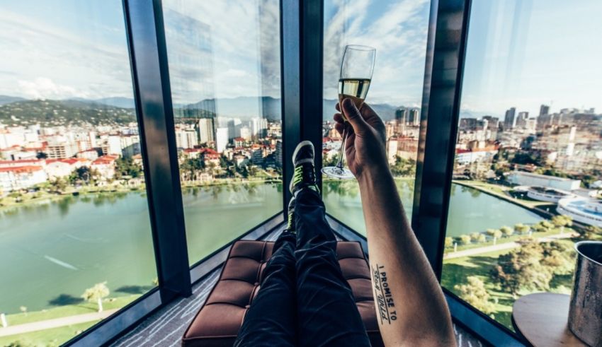 A person holding a glass of champagne while looking out over a city.