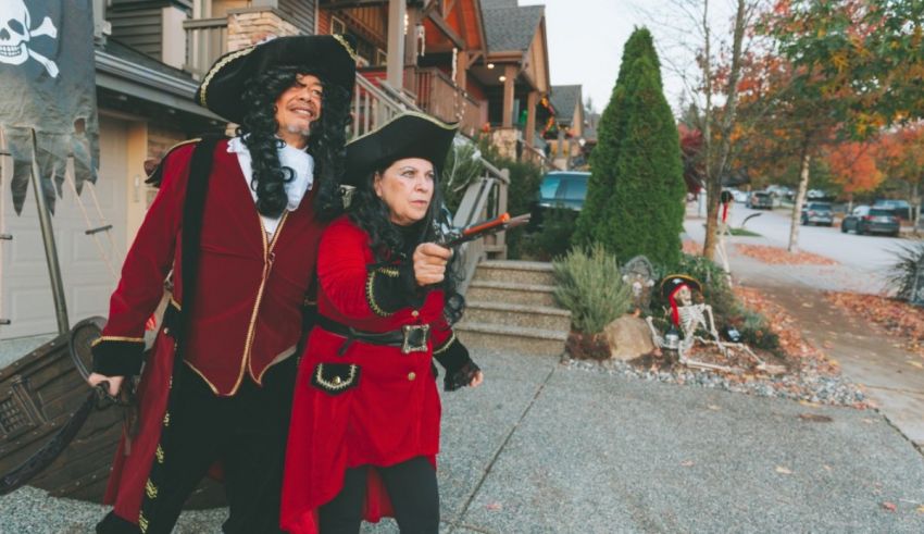 A couple dressed as pirates walking down the street.