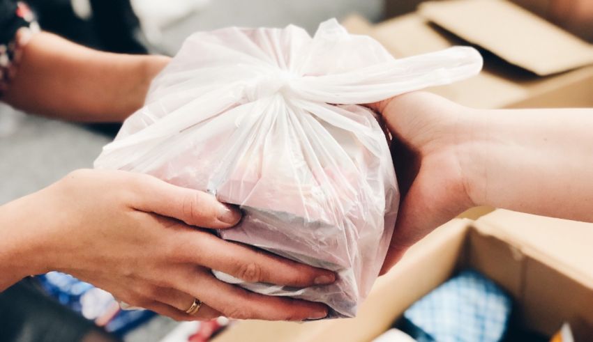 A person handing a bag of food to another person.