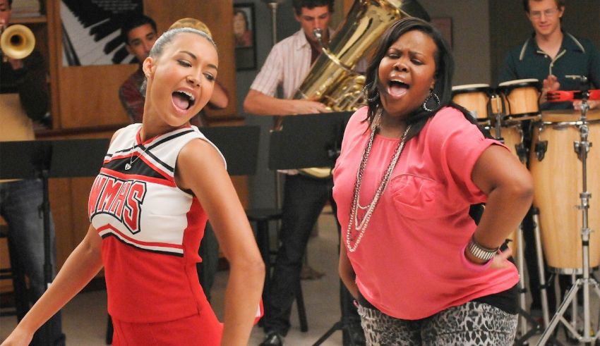 Two cheerleaders singing in front of a band.