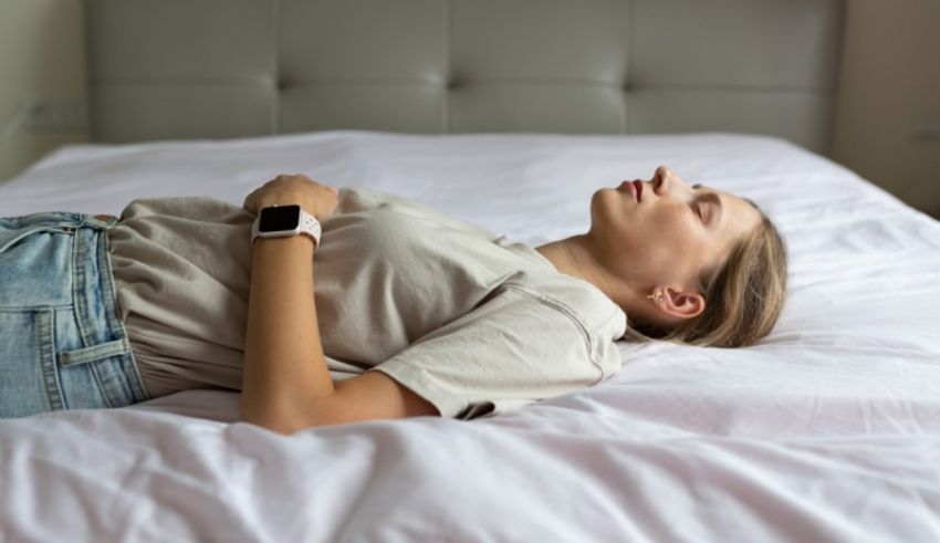 A woman laying on a bed with her hands on her hips.
