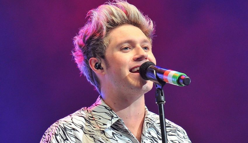 A man in a zebra print shirt singing into a microphone.