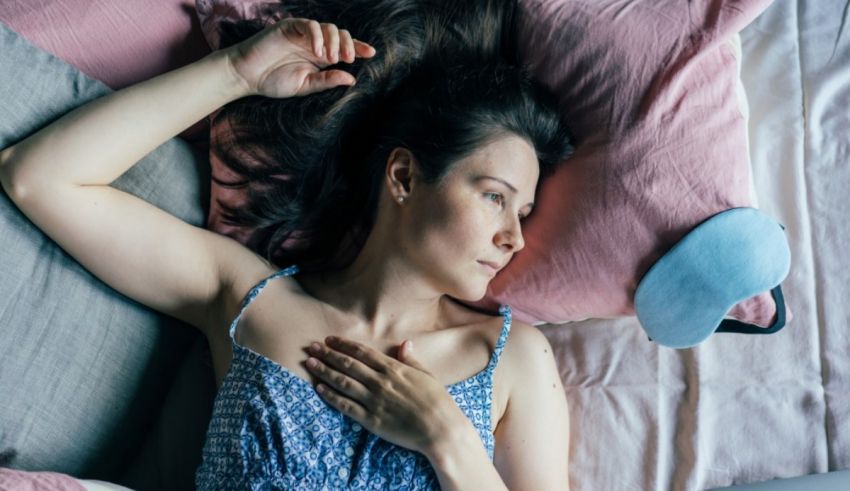 A woman laying in bed with a pillow under her head.