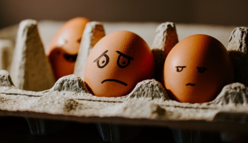 Three eggs in a carton with faces drawn on them.