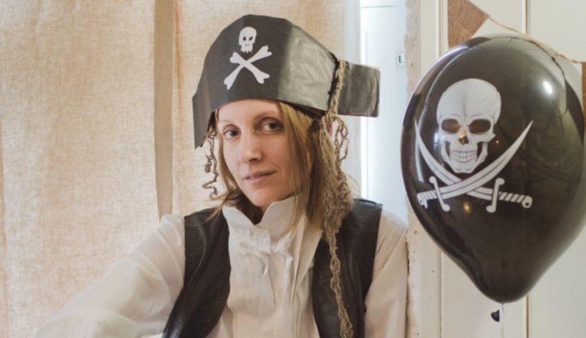 A woman in a pirate costume with balloons.
