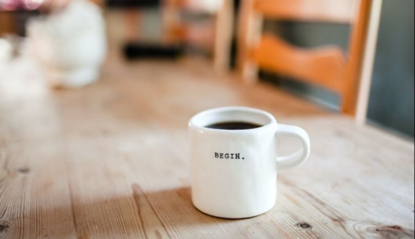 A cup of coffee sitting on a wooden table.