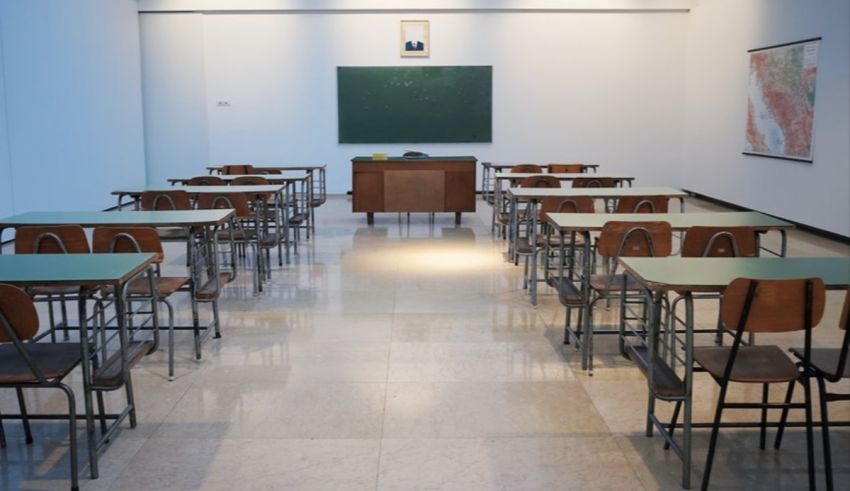 Empty classroom with desks and chalkboard.