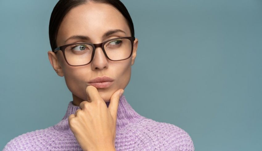 A young woman wearing glasses and thinking about something.