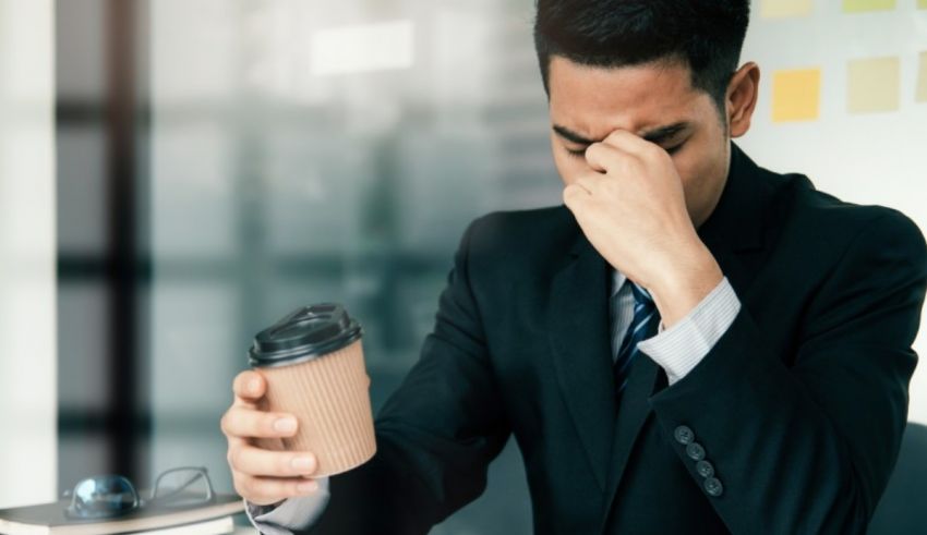 A man in a suit is holding a cup of coffee.