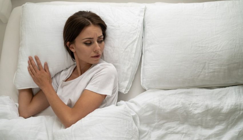 A woman laying in bed with a pillow under her head.