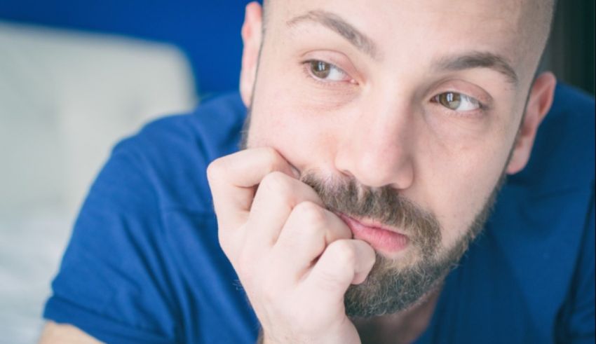 A man with a beard looking at his hand.