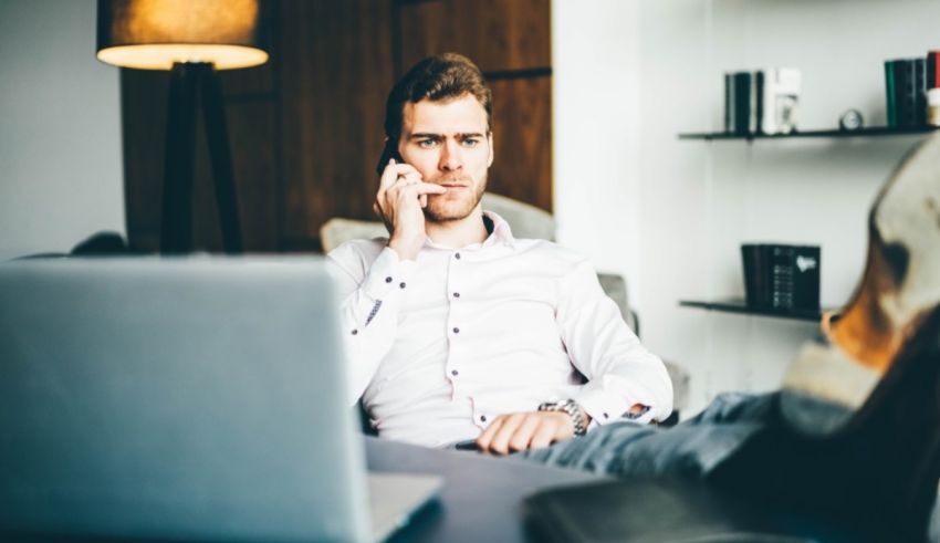 A man sitting in a chair talking on a cell phone.