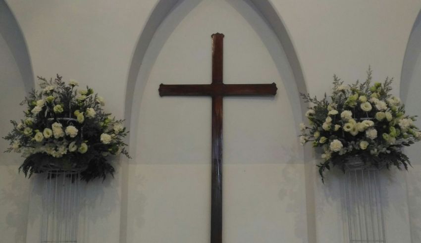 A church with a cross and flowers on the wall.