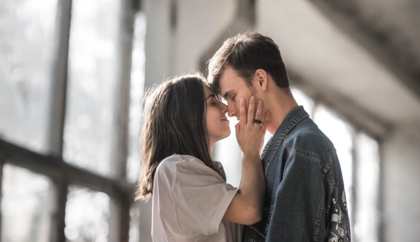 A man and woman kissing in an empty room.