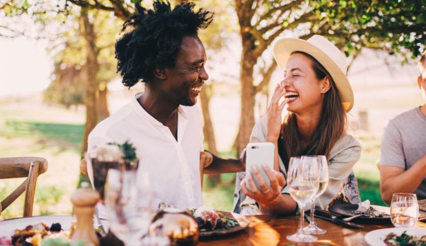 A man and woman laughing at a table.