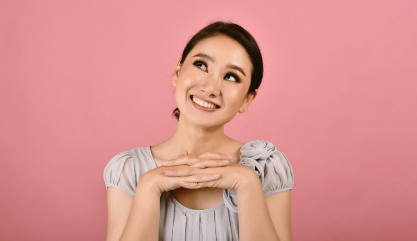 A young asian woman with her hands on her chest.