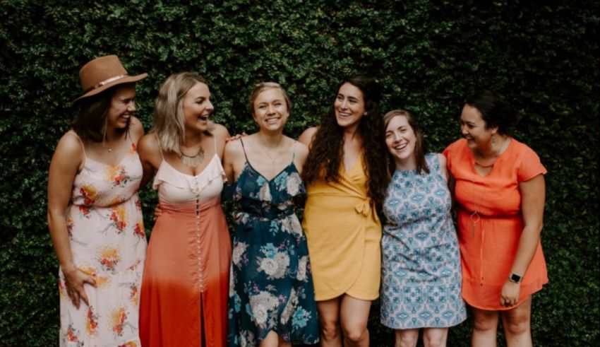 A group of women wearing colorful dresses and hats.
