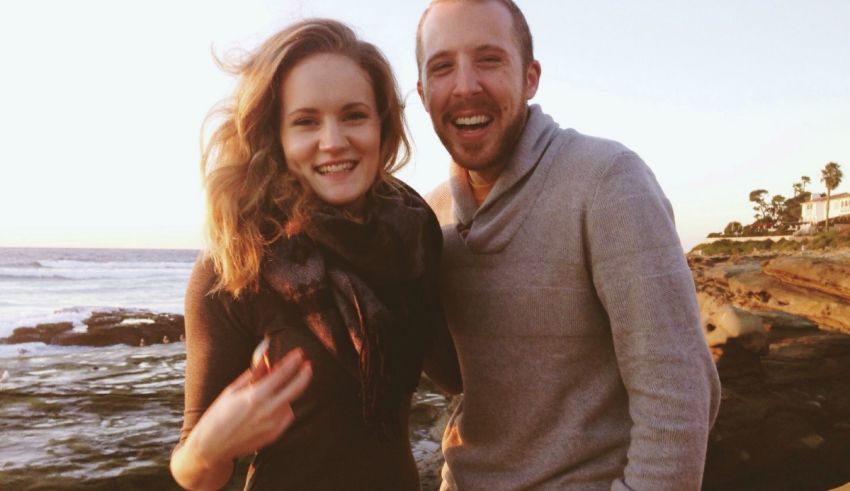 A man and woman standing together smiling.