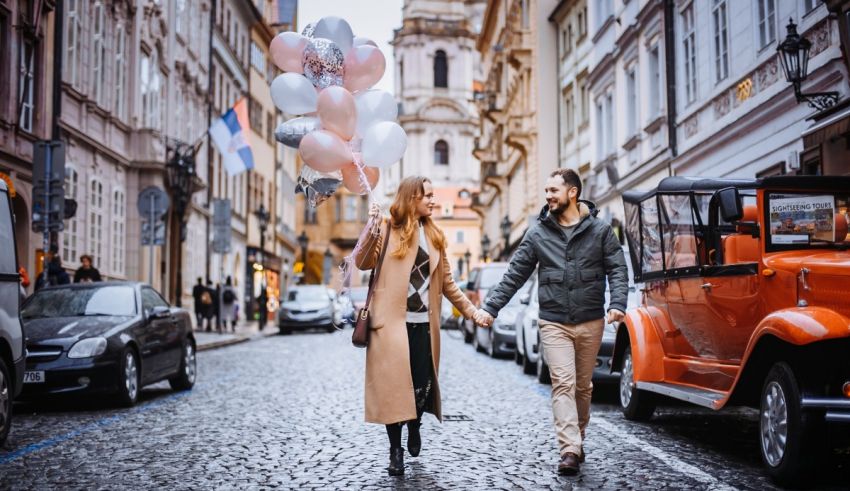 A couple walking down a street with balloons.