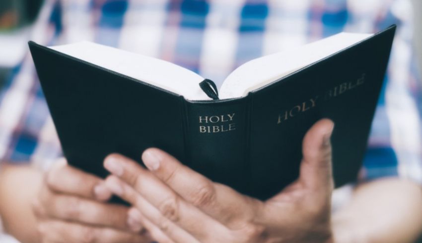 A man is holding a bible in his hands.