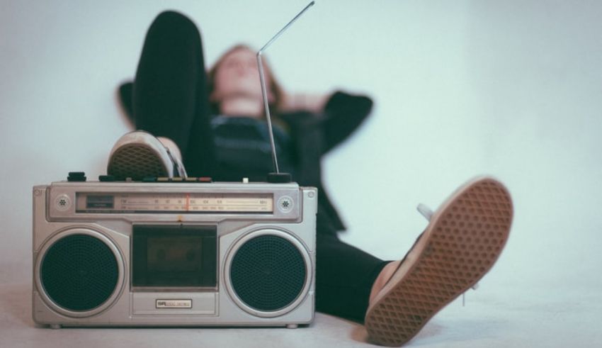 A woman laying on the floor next to a boombox.