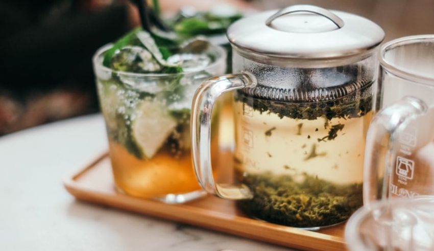 A glass of tea and a glass of water on a tray.