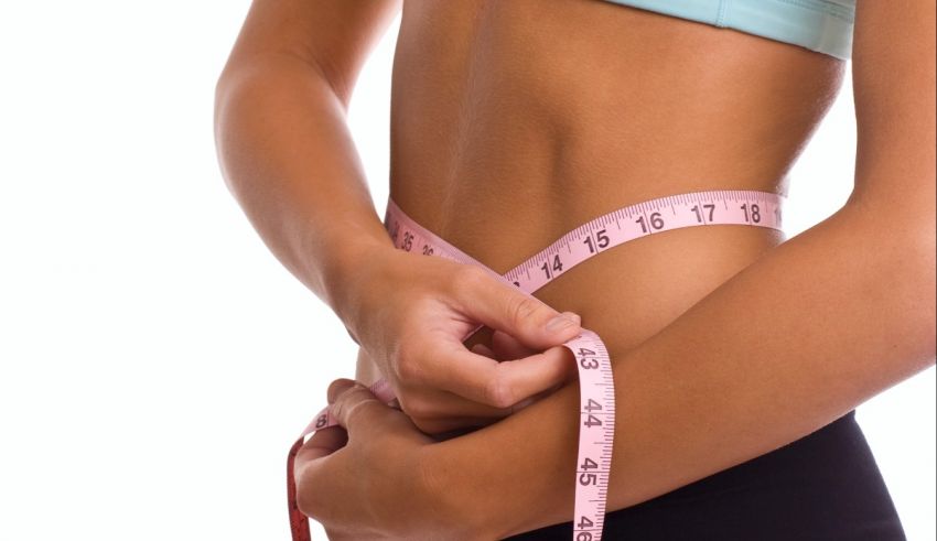 A woman measuring her waist.