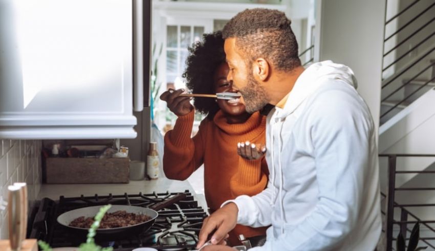 A man and woman preparing food in the kitchen.