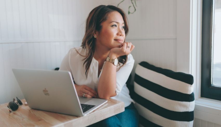 A woman sitting at a table with a laptop.