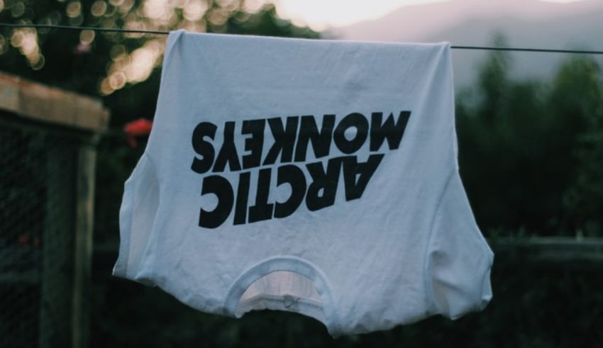 A white t - shirt hanging on a clothes line.