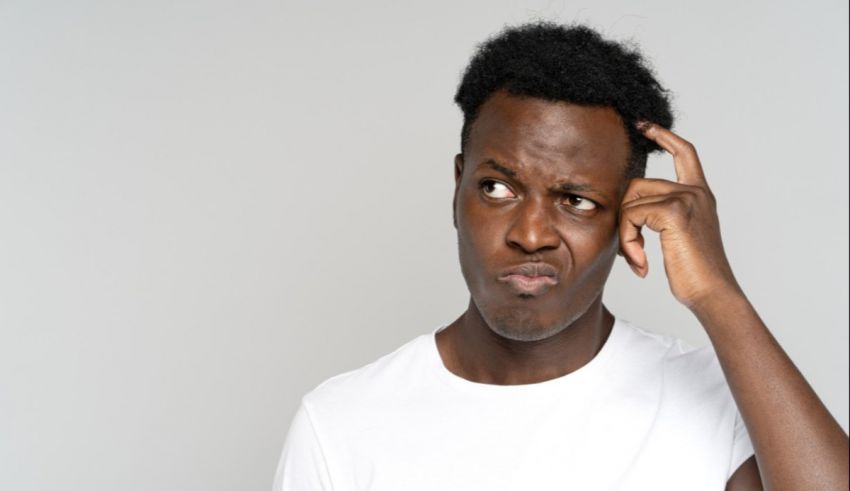 A black man with his hand on his head.