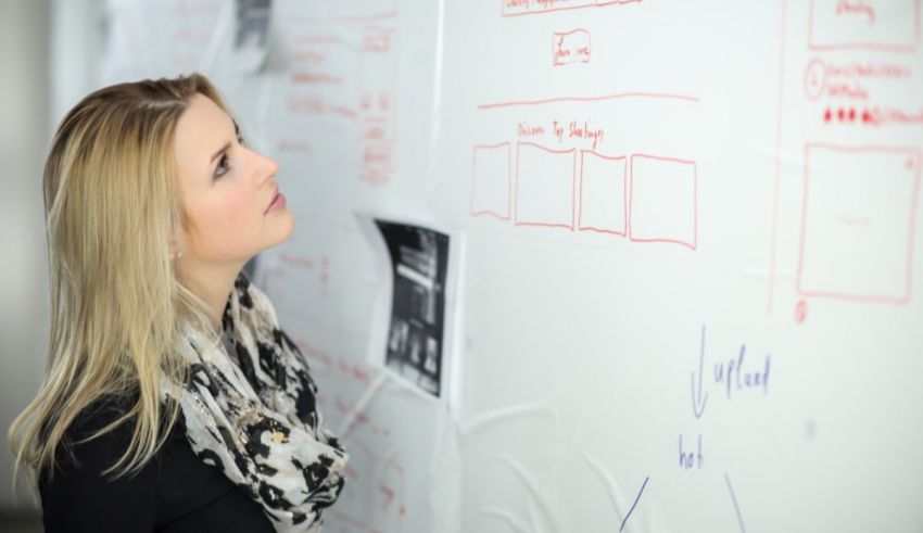 A woman looking at a white board.