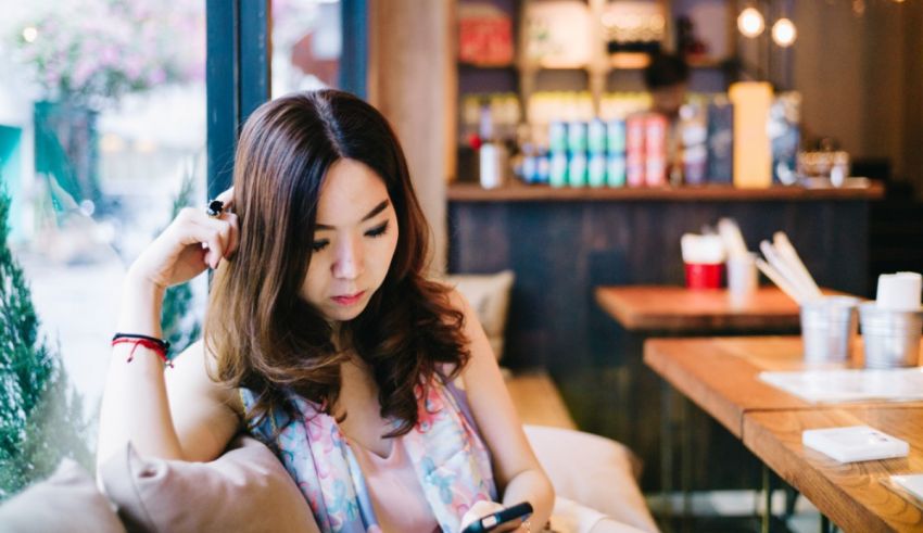 A woman sitting on a couch looking at her phone.