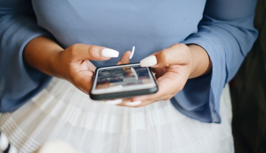 A woman is holding a cell phone in her hands.