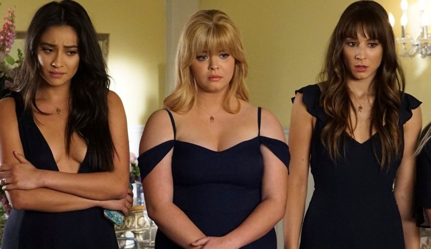 A group of women in black dresses standing next to each other.