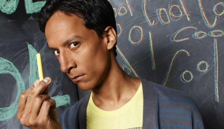 A man holding a pencil in front of a chalkboard.