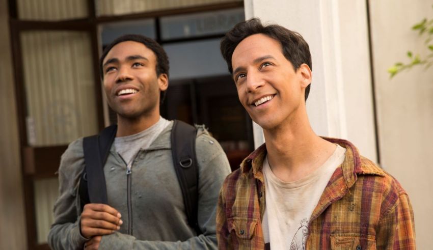 Two young men standing next to each other in front of a building.