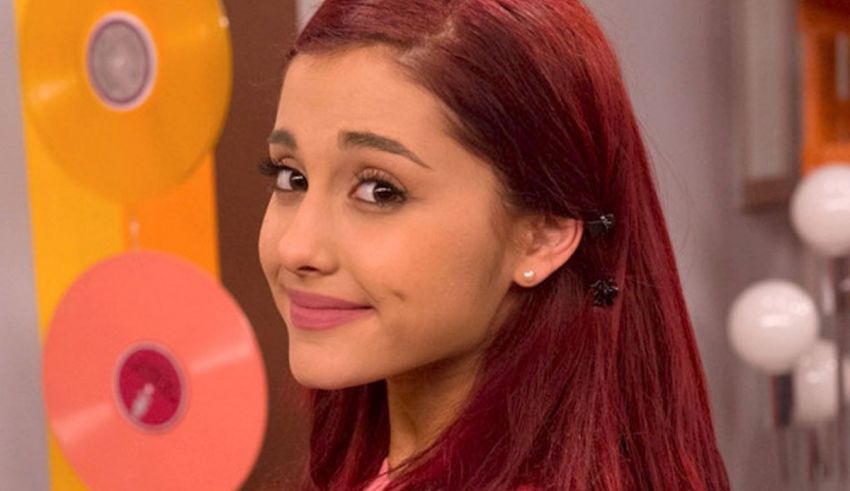 Ariana grande's hair is red and she is smiling.