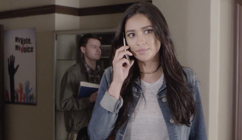 A woman talking on a cell phone in an office.