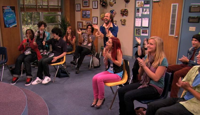 A group of people sitting in chairs and clapping.