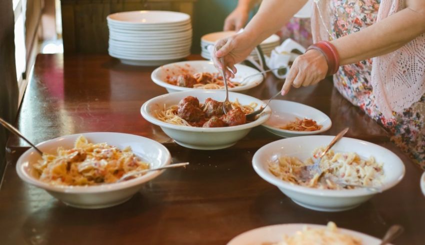 A woman is serving food from bowls on a table.