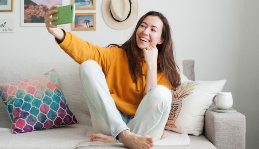 A woman sitting on a couch taking a selfie.