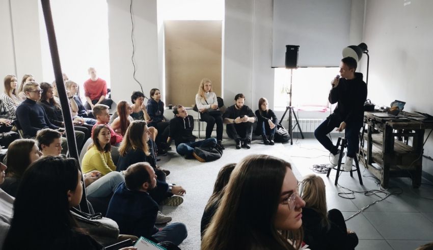 A man speaking into a microphone in front of a group of people.
