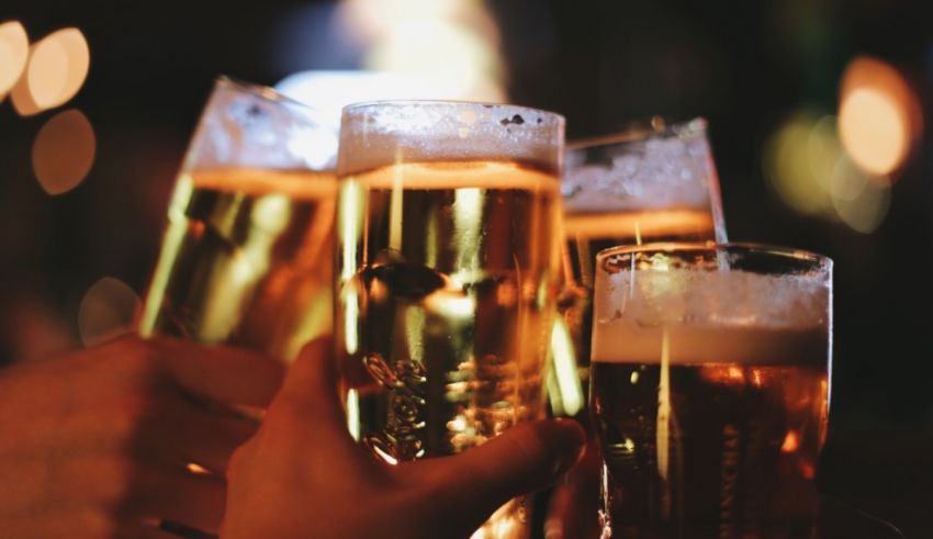 A group of people toasting beer glasses at a bar.