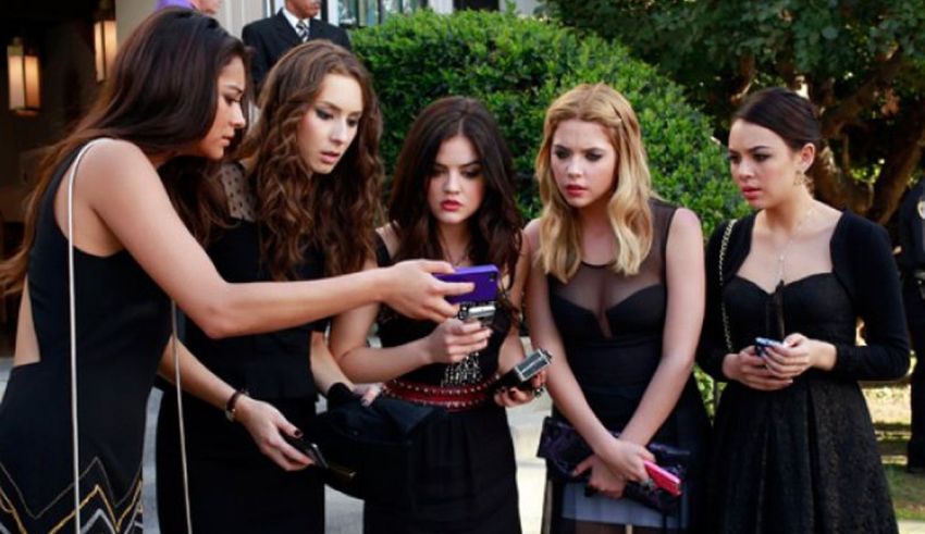 A group of women looking at a phone.